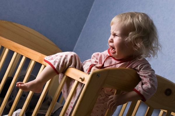 Девочка 1,5-2 лет плачет и пытается встать с постели